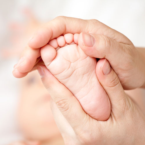 Ostéopathie du nourrisson : mobilisation douce du pied d'un bébé